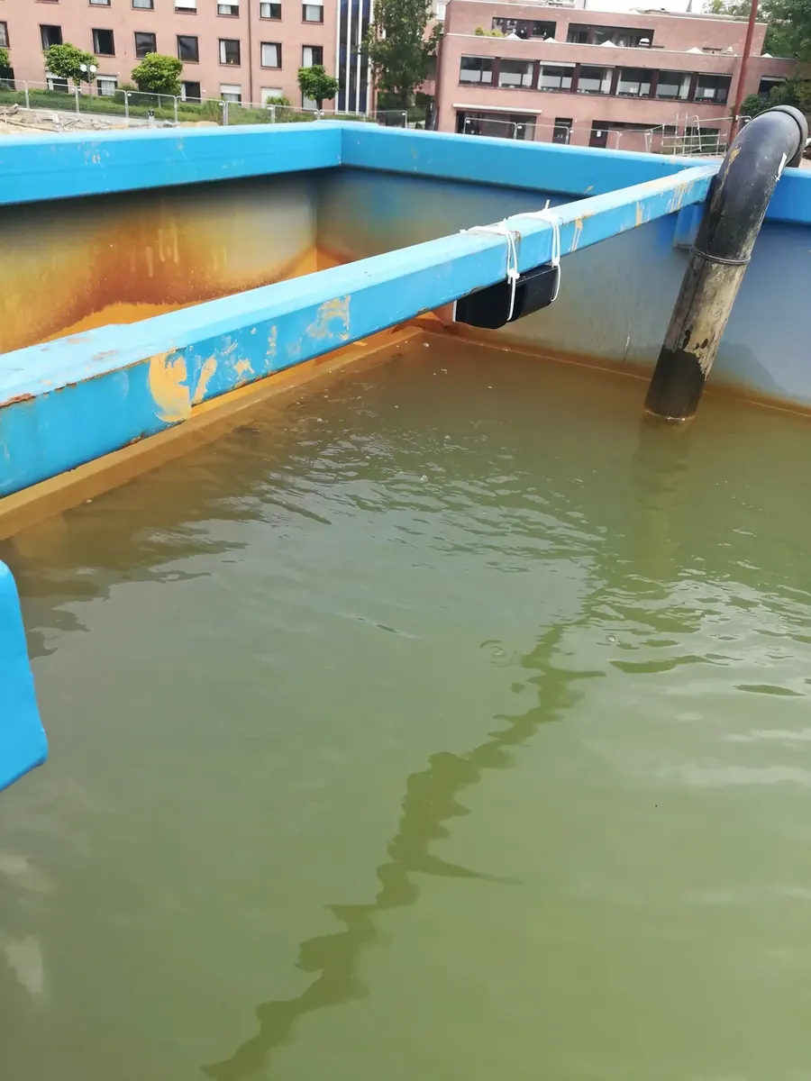 BrighterBins liquid-level sensor mounted on the rim of an open water container