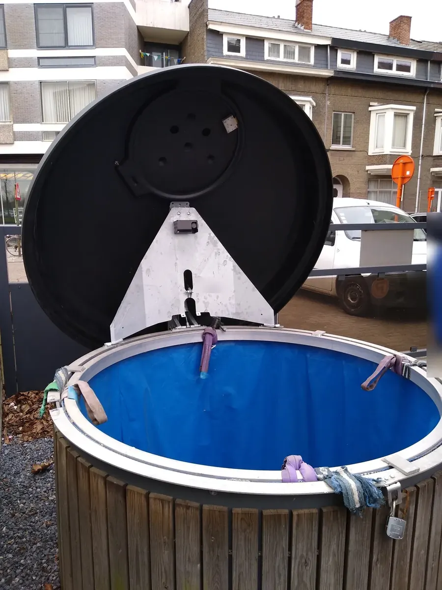 Open underground waste container with a BrighterBins sensor fitted under the lid